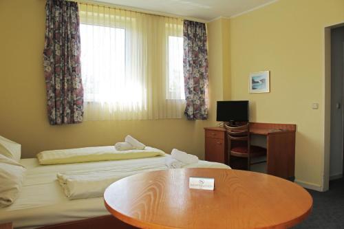 普丰斯塔特普丰施塔特奥斯特奥塔班酒店的酒店客房设有两张床和一张桌子。