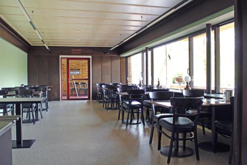 普丰斯塔特普丰施塔特奥斯特奥塔班酒店的用餐室设有桌椅和窗户。