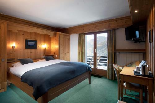 圣吕克乐美地酒店的一间卧室配有一张床、一个窗口和一张书桌