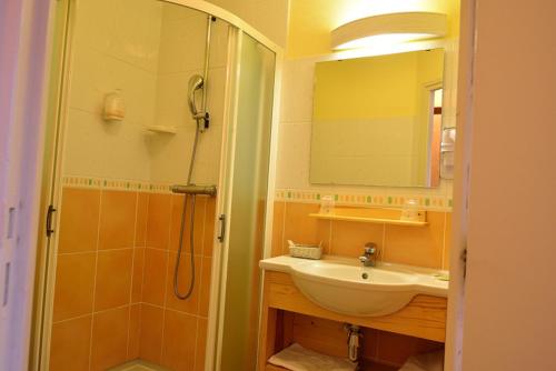 Le BéageMaison VERNET - Hôtel Beauséjour的浴室配有盥洗盆和带镜子的淋浴