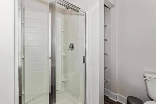 彭萨科拉LUXURY TOWNHOME NEAR DOWNTOWN AND PENSACOLA BEACH的一间带卫生间的浴室内的玻璃淋浴间
