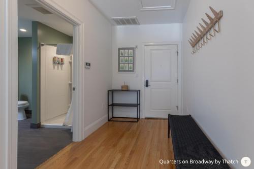 波士顿West Broadway Quarters by Thatch的一间设有门廊的客房,铺有木地板