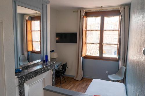 图卢兹库瓦巴拉农酒店的小房间设有书桌和窗户