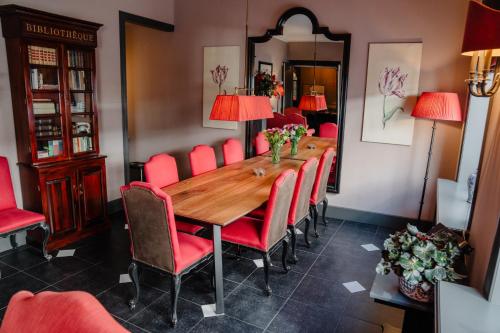 海牙帕雷斯酒店的一间带木桌和红色椅子的用餐室