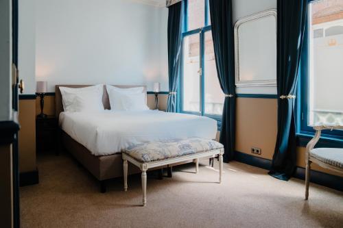 海牙帕雷斯酒店的卧室配有床、长凳和窗户。