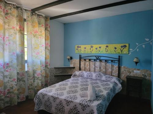 TamajónHotel rural la casona de Tamaya的蓝色客房中一间带床的卧室