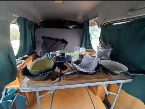 圣克鲁斯-德特内里费Beautiful Campervan to Rent的放碗和平底锅的野营车后面的桌子