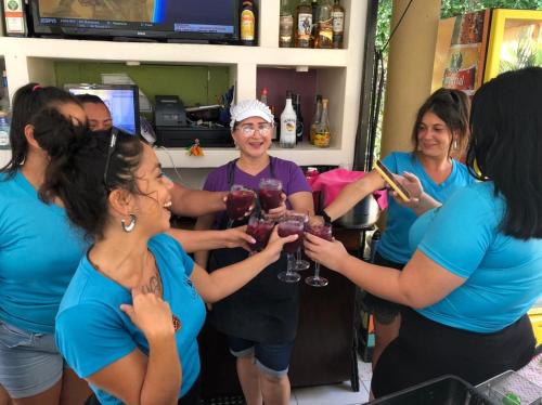 雅科拉斯布里萨别墅度假村 的一群妇女站在一个酒吧周围,拿着酒杯