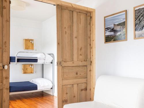 扎鲁亚斯Zarautz Hostel的一间小卧室,配有双层床和一扇门