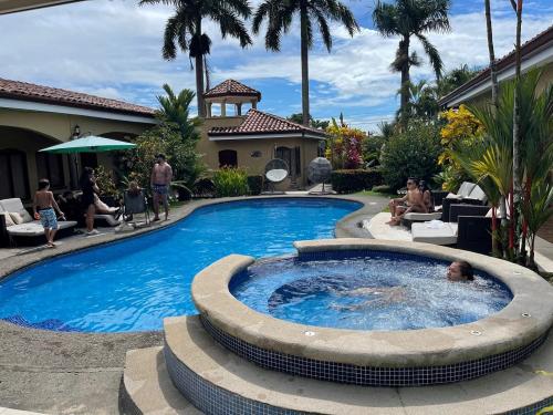 雅科拉斯布里萨别墅度假村 的院子里的游泳池,周围的人坐在游泳池周围