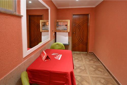 里约热内卢Caravellas Hotel的室内的红色桌子和绿色椅子