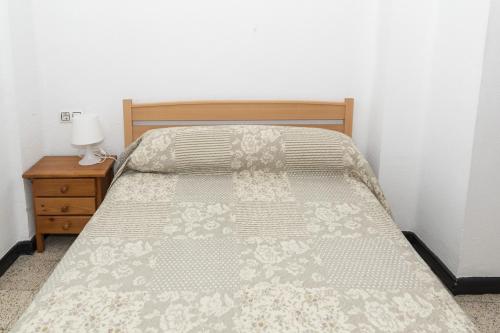 库列拉Estirpe, 4º-8的卧室内的一张床位,配有木制床头板和桌子