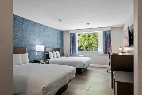 沃特敦Inn On Arsenal的酒店客房设有两张床和窗户。