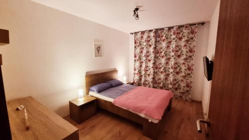 蒂米什瓦拉Forest Apartment Timișoara的一间带床和窗帘的小卧室