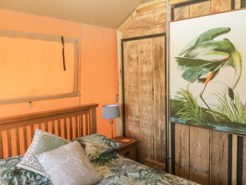 托特尼斯Semira Tent Lodge的卧室配有一张床,墙上挂着一幅大画
