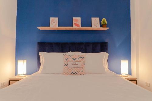 Le KramLe Majorelle de Carthage的一间卧室设有蓝色的墙壁和一张带两盏灯的床。
