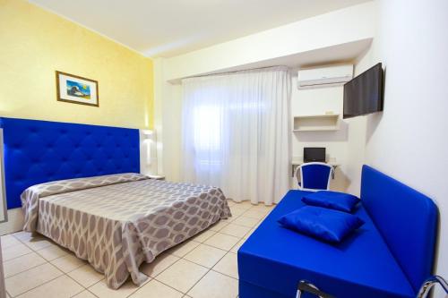 圣贝内代托-德尔特龙托Hotel Haus Charlotte的一间卧室配有蓝色的床和蓝色的沙发