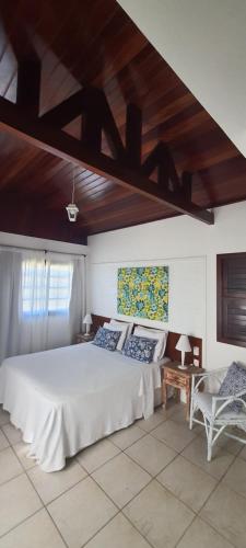 皮帕提堡拉戈阿酒店的卧室设有白色的床和木制天花板。