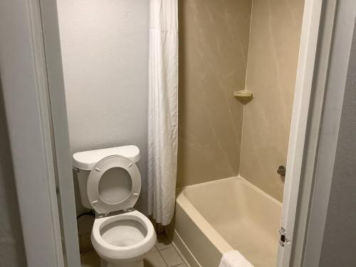 基西米Heritage Park Inn的一间带卫生间和浴缸的小浴室