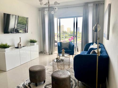 圣多明各Super Luxurious L6 Sky Blue Apartment的客厅配有蓝色的沙发和两把椅子