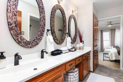 圣安东尼奥Salt Water Pool & Backyard Oasis @ Wild Eagle的浴室设有水槽和墙上的两面镜子