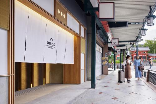 京都OMO5 Kyoto Gion by Hoshino Resorts的两个人在商店前的一条人行道上走