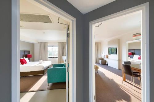 达尔文Exclusive Harbourfront - Two Adjacent Stays with Pool的一间卧室设有一张床和一间客厅。