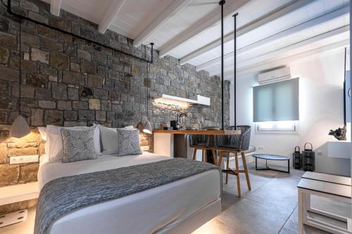 阿波罗尼亚Manesis Suites的一间卧室设有一张床和石墙
