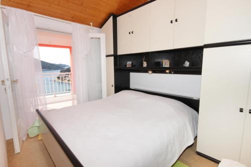 尼亚卢卡Apartments with a parking space Vela Luka, Korcula - 7551的卧室配有白色的床和窗户。