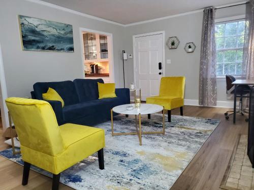 蒙哥马利Cheerful 2 BR Near Colleges, Downtown, Attractions的客厅配有蓝色的沙发和2把黄色的椅子
