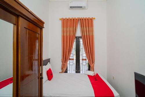 帕朗卡拉亚RedDoorz Syariah @ Jalan Tingang Palangkaraya的一间卧室设有一张床和一个窗口