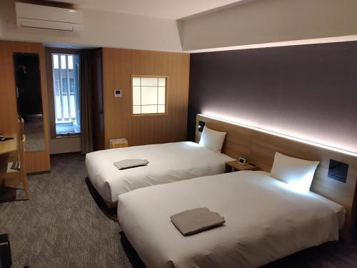 京都ALA HOTEL KYOTO的酒店客房设有两张床和窗户。