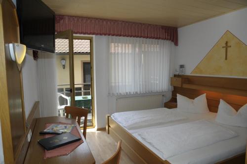 MitteleschenbachGasthof Zur Krone的酒店客房配有一张床和一张带笔记本电脑的桌子
