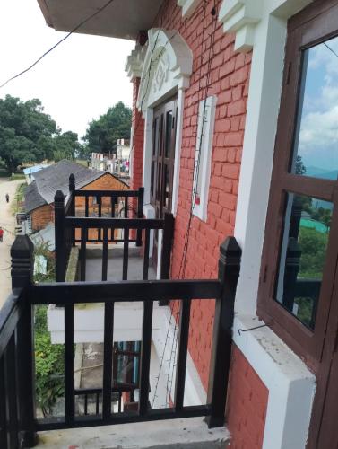 班迪普尔Hotel small town guest house的一个带黑色栅栏的红砖房子的阳台