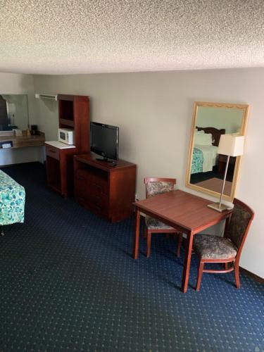阿灵顿Smokey Point Motor Inn的酒店客房设有一张桌子、一张床和镜子