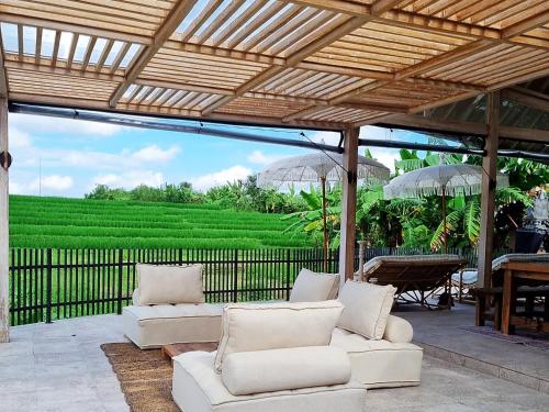 坎古Stay at My Place Bali的庭院配有白色的沙发、遮阳伞和一张桌子。