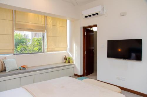 拉维尼亚山ARON'S Lavinia SAPPHIRE的白色的客房设有电视和窗户。
