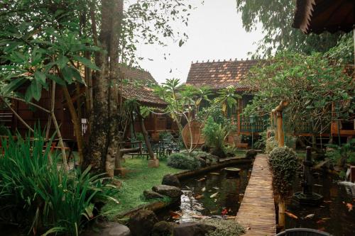 斯勒曼Cokro Hinggil - Traditional View的房屋前带池塘的花园