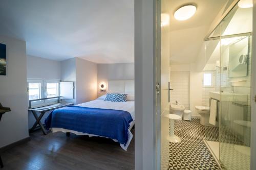蒙达卡Hotel&Spa El Puerto的一间带床的小卧室和一间浴室