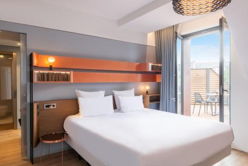 圣马洛圣马洛格兰德金色郁金香酒店的一间带一张白色大床的卧室和一个阳台