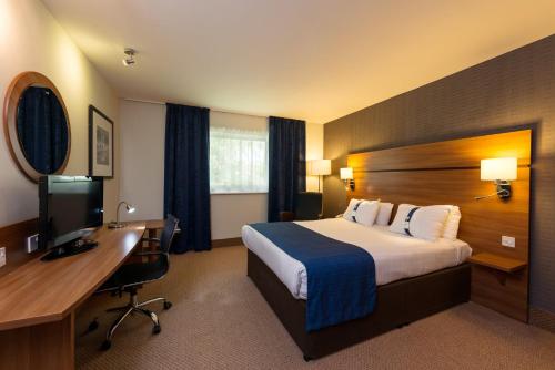 什鲁斯伯里什鲁斯伯里快捷假日酒店的配有一张床和一张书桌的酒店客房