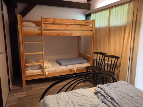 希格斯多夫沃拉夫山林小屋的一间卧室配有双层床、一张床和一把椅子