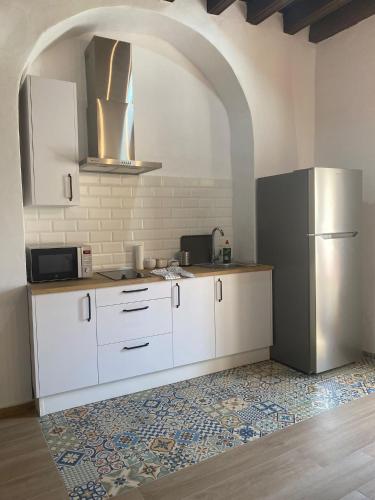 赫雷斯-德拉弗龙特拉LA VENDIMIA的厨房配有白色橱柜和冰箱。