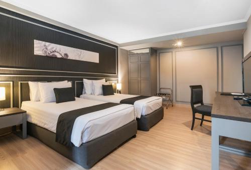 曼谷SC Park Hotel的酒店客房配有两张床和一张书桌