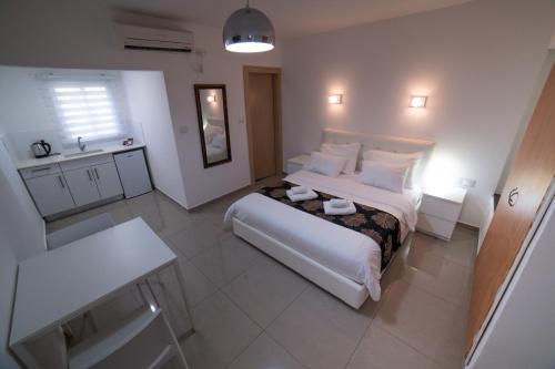 亚实基伦Agamim Hotel Ashkelon的卧室配有白色大床和水槽
