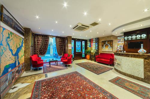 伊斯坦布尔马格诺拉宫殿酒店的客厅配有红色椅子和世界地图