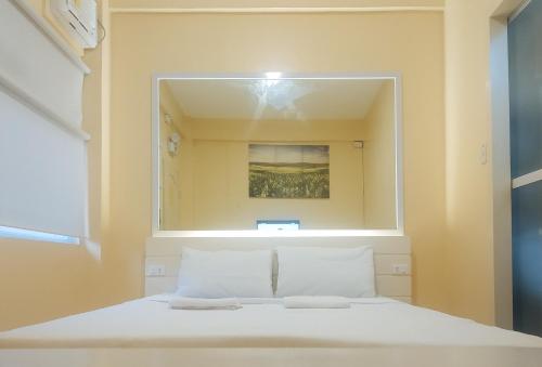 OraconRedDoorz @ Southern Suites Guimaras的卧室配有大镜子,位于床上方