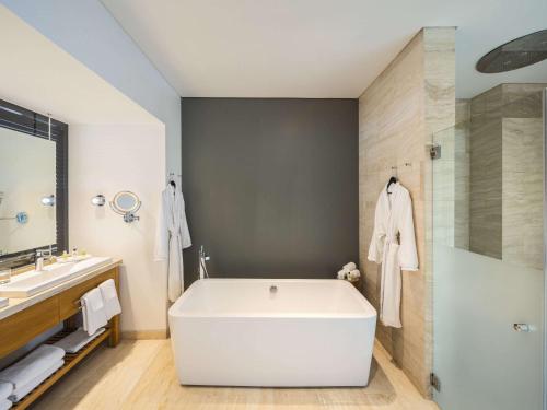 墨西哥城The Paragon Hotel Mexico Santa Fe By Accor的浴室配有白色浴缸和淋浴。