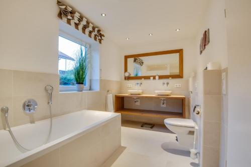 施利尔塞Ferienhaus Seehof mit Sauna & offenem Kamin的带浴缸、卫生间和盥洗盆的浴室