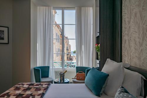 戛纳BW Premier Collection Mondial的酒店客房设有一张床和一个大窗户
